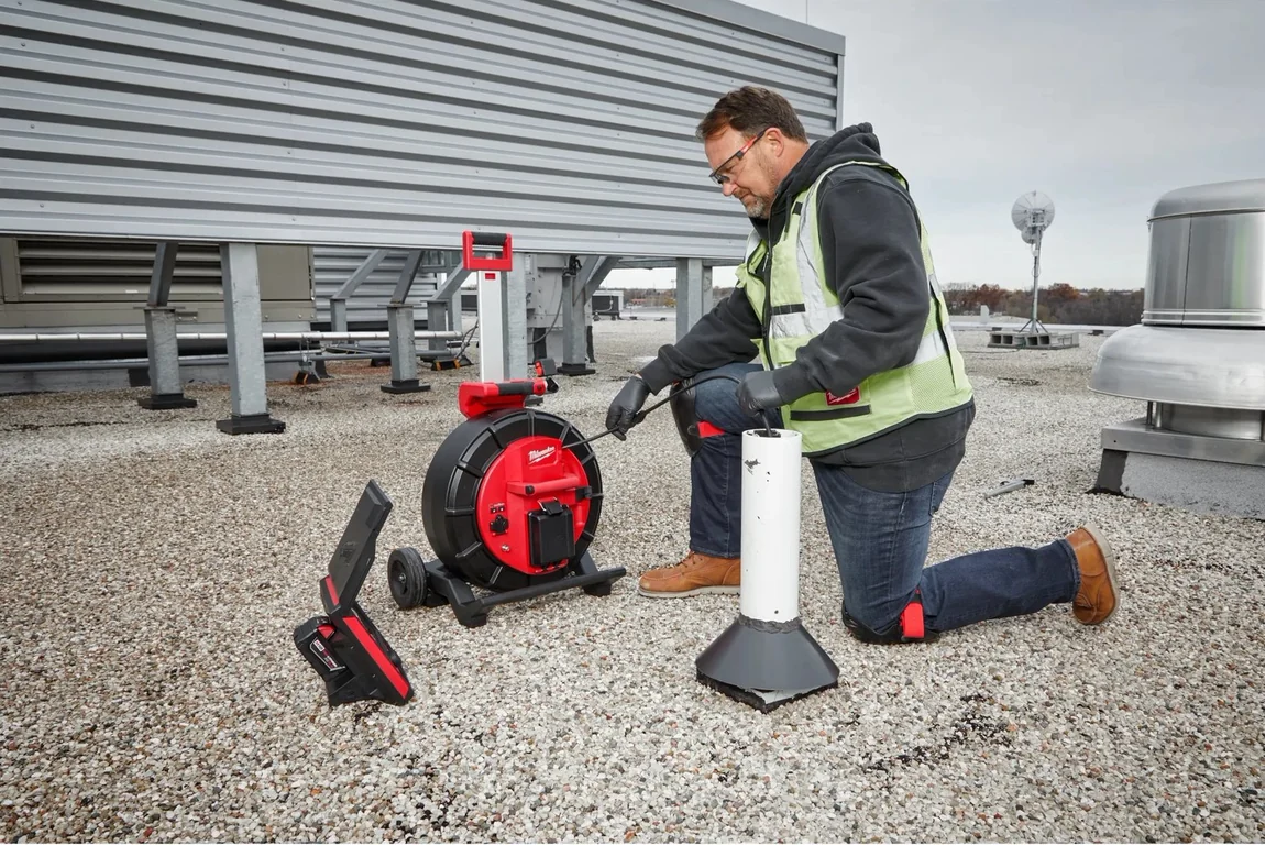 A technician running the inspection system on a commercial roof stack